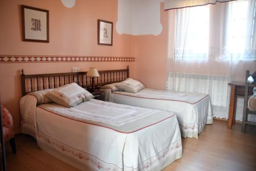 卢耶哥索摩查Casa Rural Molino Del Arriero的带窗户的客房内的两张床