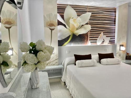 索托德拉马里纳埃尔加丁酒店的卧室配有白色的床和花瓶
