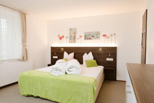沃尔特湖畔韦尔登Velden24 - create your own stay的卧室配有一张带绿床单和枕头的大床。