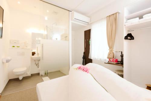 沃尔特湖畔韦尔登Velden24 - create your own stay的白色的浴室设有白色的床和卫生间。