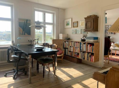 哥本哈根ApartmentInCopenhagen Apartment 1454的客厅配有桌子和书架