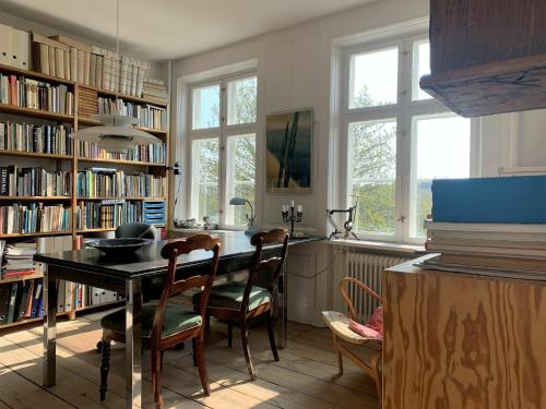 哥本哈根ApartmentInCopenhagen Apartment 1454的图书馆里带桌椅的房间
