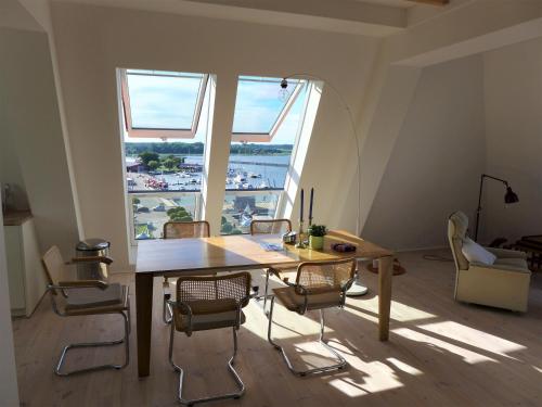 巴特Speicher Residenz Barth E7 App 1的配有大窗户的客房内的桌椅
