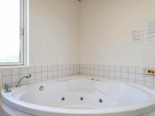 法贾德嘉德8 person holiday home in Ulfborg的带窗户的浴室内的白色大浴缸