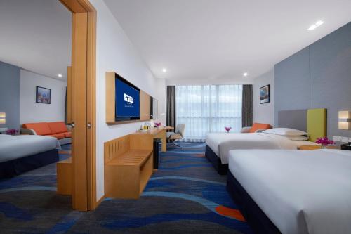 郑州郑州郑东智选假日酒店的酒店客房配有床铺和平面电视。