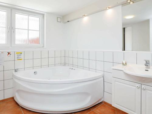 布拉万德4 person holiday home in Bl vand的白色的浴室设有浴缸和水槽。