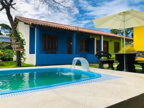 卡波布里奥Casas Aconchegantes Temporada的房屋前的游泳池
