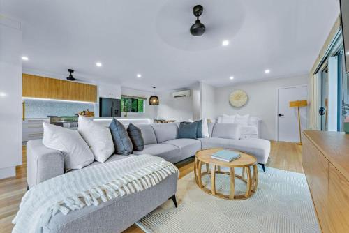 埃尔利海滩Airlie Abode的客厅配有沙发和桌子