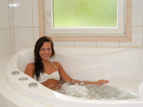 亨讷斯特兰德6 person holiday home in Henne的女人坐在浴缸里