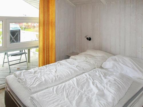 盖尔廷Two-Bedroom Holiday home in Gelting 1的窗户客房内的一张带白色床单的床