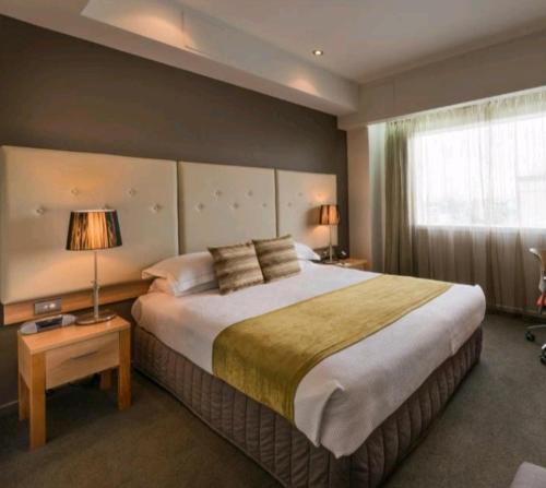 地拉那Hotel Artist的一间卧室设有一张大床和一个窗户。