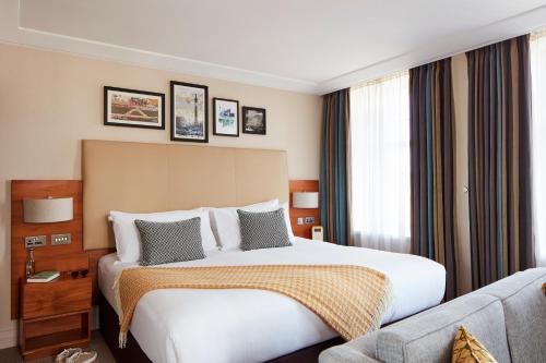 伦敦The Clermont London, Charing Cross的酒店客房,配有床和沙发