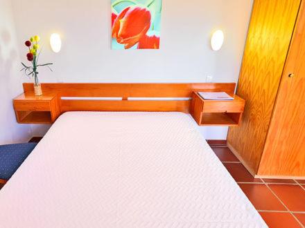 科武港Parque de Campismo da Ilha do Pessegueiro的卧室配有一张白色大床