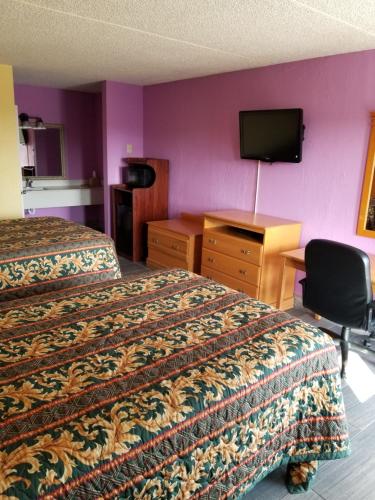 赫米蒂奇Hermitage Inn的酒店客房设有两张床、一张桌子和一台电视。
