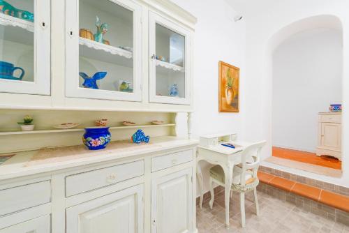 波西塔诺Casa Pietro的厨房配有白色橱柜和桌子