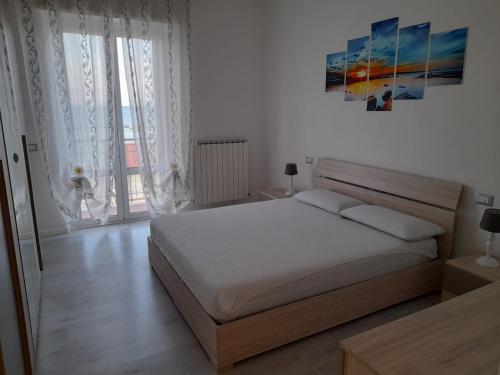 法尔科纳拉·玛里提马Appartamento Fronte Mare的卧室配有一张床,墙上挂有绘画作品