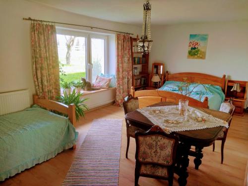 KiwityZakątek Szczęścia的一间卧室配有一张床、一张桌子、一张床和一个窗户。
