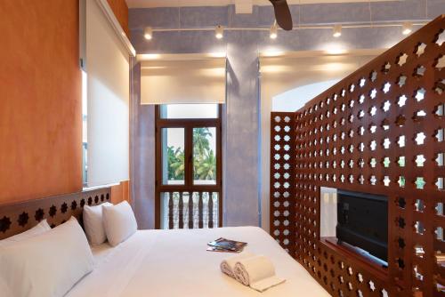 卡塔赫纳Ganem Suites Cartagena的一间卧室设有一张带壁炉和电视的床。