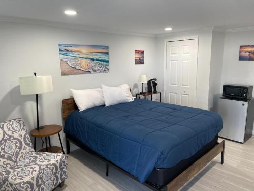 阿米莉亚岛The Surf Beach Motel的一间卧室配有蓝色的床和椅子