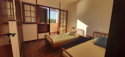 布希奥斯Charmosa Casa Marina Porto Búzios的小房间设有两张床和窗户