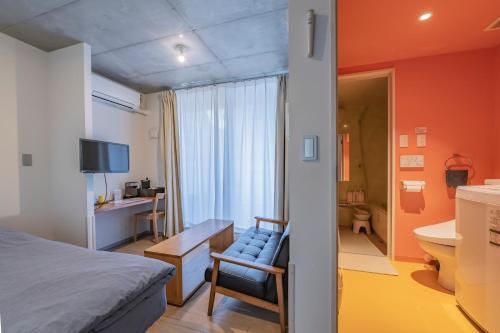 东京新宿大久保bmj公寓式酒店的一间卧室配有一张床和一把椅子,还有一间浴室