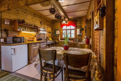 比亚沃维耶扎MorzeLas Chata Białowieża的厨房配有桌椅和白色冰箱。