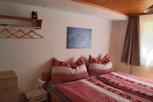 坎德施泰格Harri's BnB in Kandersteg, Ferienwohnung的一间卧室配有两张带红白色枕头的床