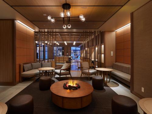 札幌Sapporo Granbell Hotel的大堂设有壁炉和桌椅。