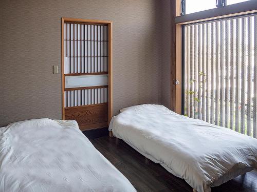 香取市克艾杜旅舍的一间卧室设有一张床和一个大窗户