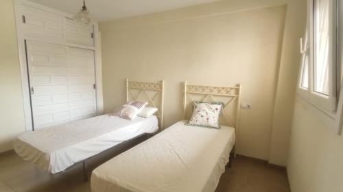 阿瓜杜尔塞Expoholidays - Apartamento en primera linea的一间卧室设有两张床和窗户。