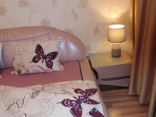陶格夫匹尔斯Central Cietokšņa Street Apartment的客厅配有带蝴蝶的沙发,位于枕头上