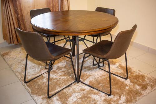 洛德瓦尔Lodwar Acacia Residences的地毯上的一张木桌和四把椅子