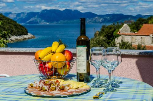 赞吉纳Apartment Bay of Dreams的一张桌子,上面放着一碗水果和一瓶葡萄酒