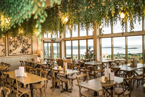 盖特豪斯厄夫弗利特Sea View Snugs at Laggan的一间设有桌椅的餐厅,位于带窗户的房间内