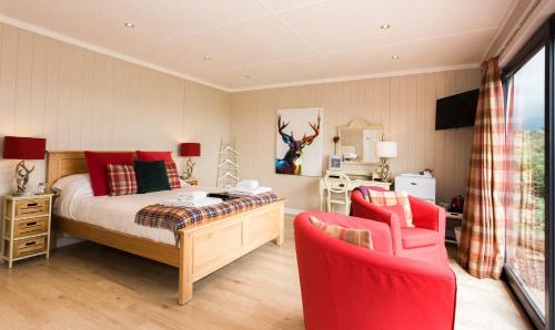 盖特豪斯厄夫弗利特Sea View Snugs at Laggan的一间卧室配有一张床和两张红色椅子