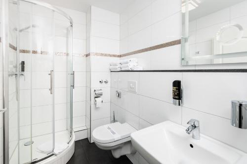 奥芬巴赫凯撒霍夫城市酒店的白色的浴室设有卫生间和水槽。