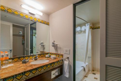 库利亚坎Hotel Lucerna Culiacan的一间带水槽、淋浴和镜子的浴室