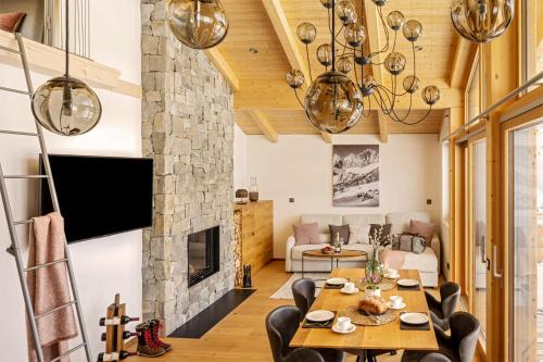 拉姆绍达赫斯坦Alpin Residenz Dachsteinperle的客厅配有桌椅和壁炉