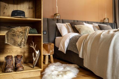 拉姆绍达赫斯坦Alpin Residenz Dachsteinperle的一间卧室配有带靴子和地毯的床