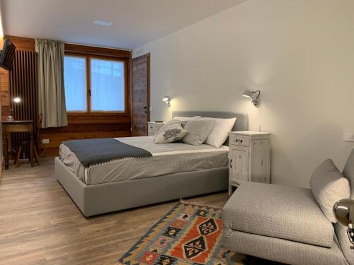 尚波吕克lo Miete di Nonni的一间卧室配有一张床、一张沙发和一把椅子