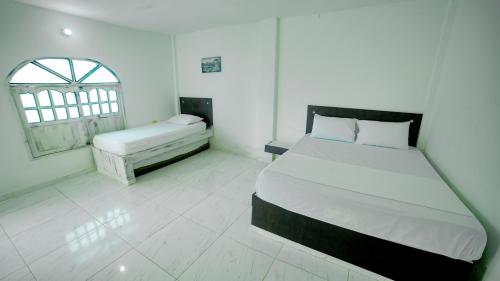 托卢Hotel Kevins的白色的卧室设有床和窗户