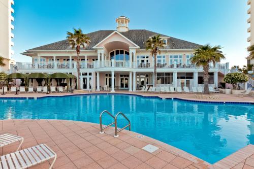 格尔夫海岸The Beach Club Resort and Spa的一座大房子,前面设有一个游泳池