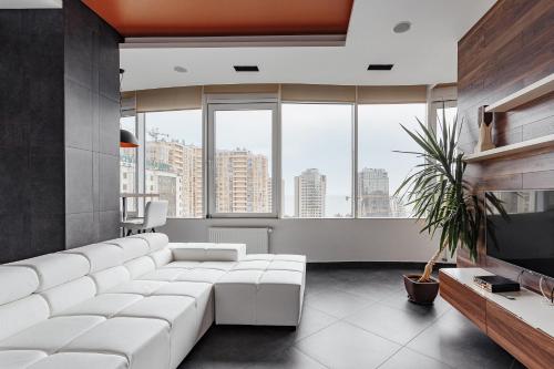 敖德萨皇家公寓的客厅设有大型白色沙发和大窗户