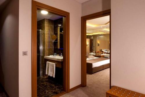 KarşıyakaMAJURA HOTEL BUSINESS的带淋浴、盥洗盆和镜子的浴室