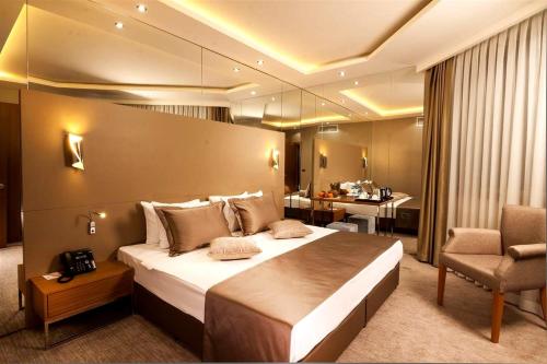 KarşıyakaMAJURA HOTEL BUSINESS的酒店客房带一张大床和一把椅子