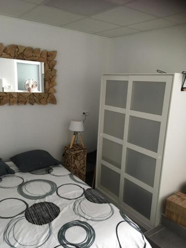 多勒L’appartement charmant的一间卧室配有一张床和镜子