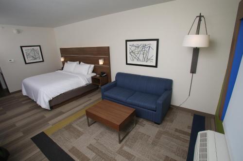 麦库克Holiday Inn Express - McCook, an IHG Hotel的酒店客房,配有一张床和一张蓝色椅子