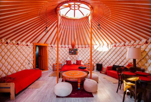 克沃兹科Całoroczne jurty mongolskie - "Domy Słońca"的圆顶帐篷配有红色的沙发和桌子