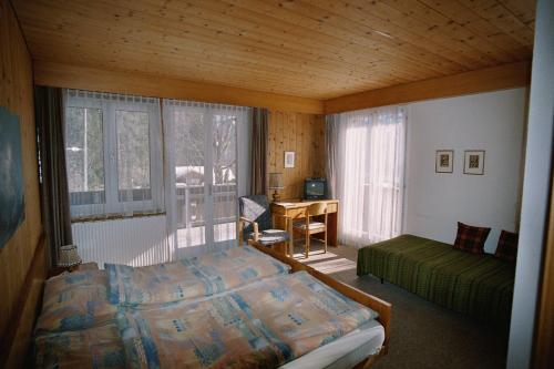 格林德尔瓦尔德贝拉里酒店的卧室配有一张床、一张书桌和窗户。