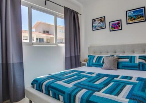 蓬塔卡纳Apartamento Deluxe para Parejas en Punta Cana的一间卧室设有一张床和一个大窗户